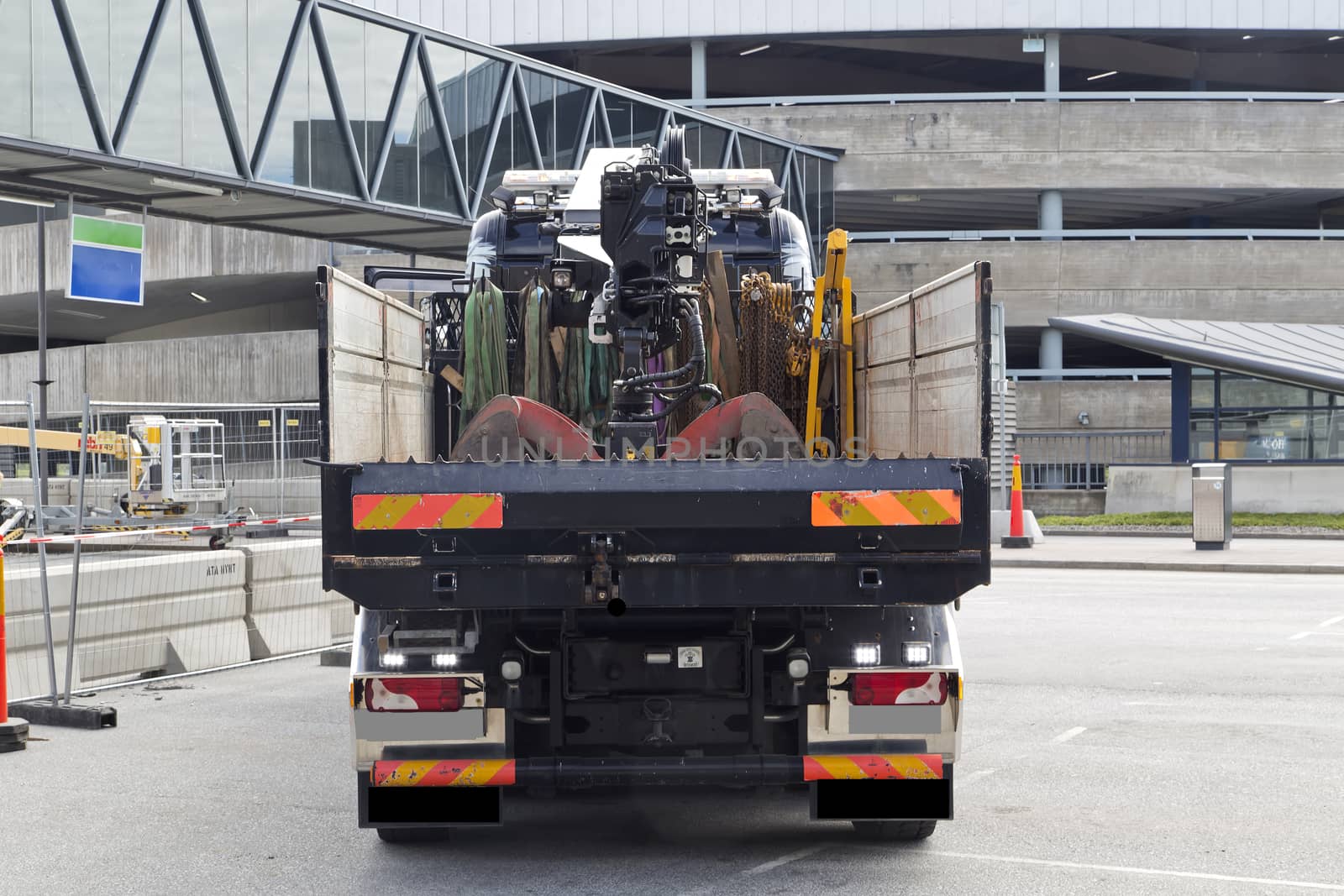 A truck with a lifting device on a construction site.