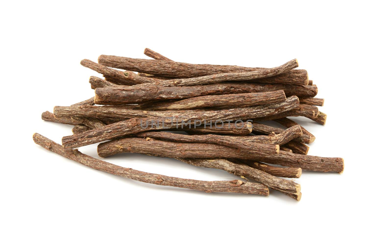 Large pile of liquorice root sticks, isolated on a white background