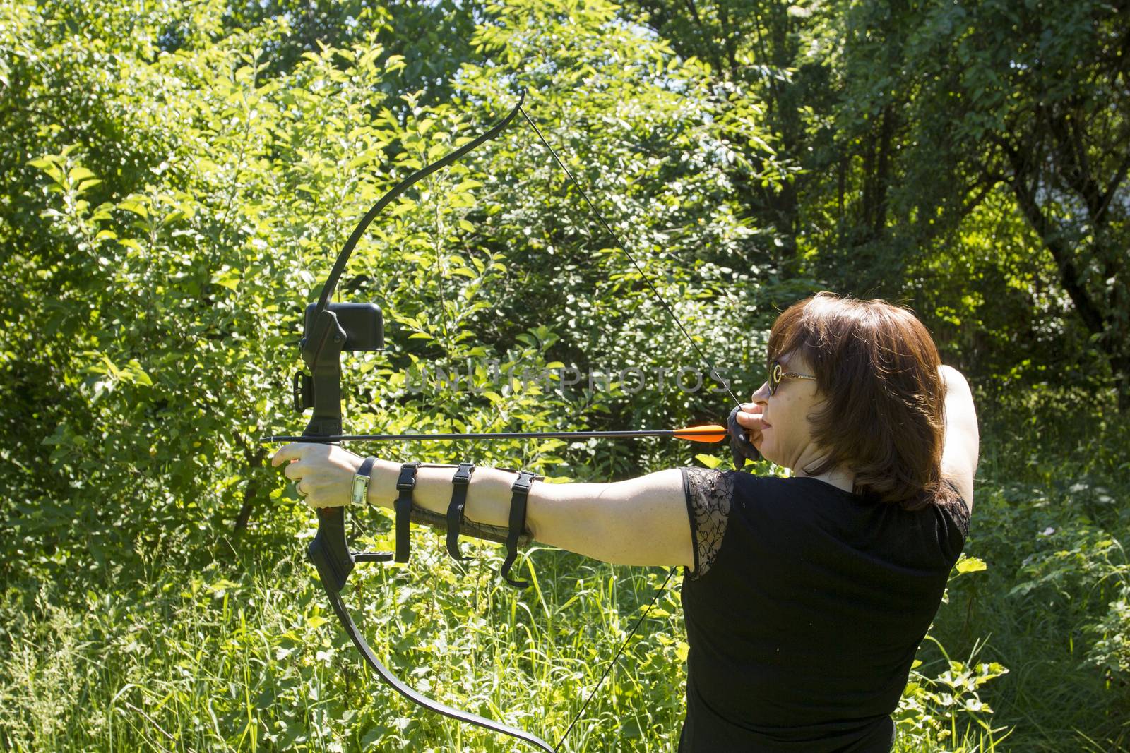 Woman shoots a bow. Sports - Archery.