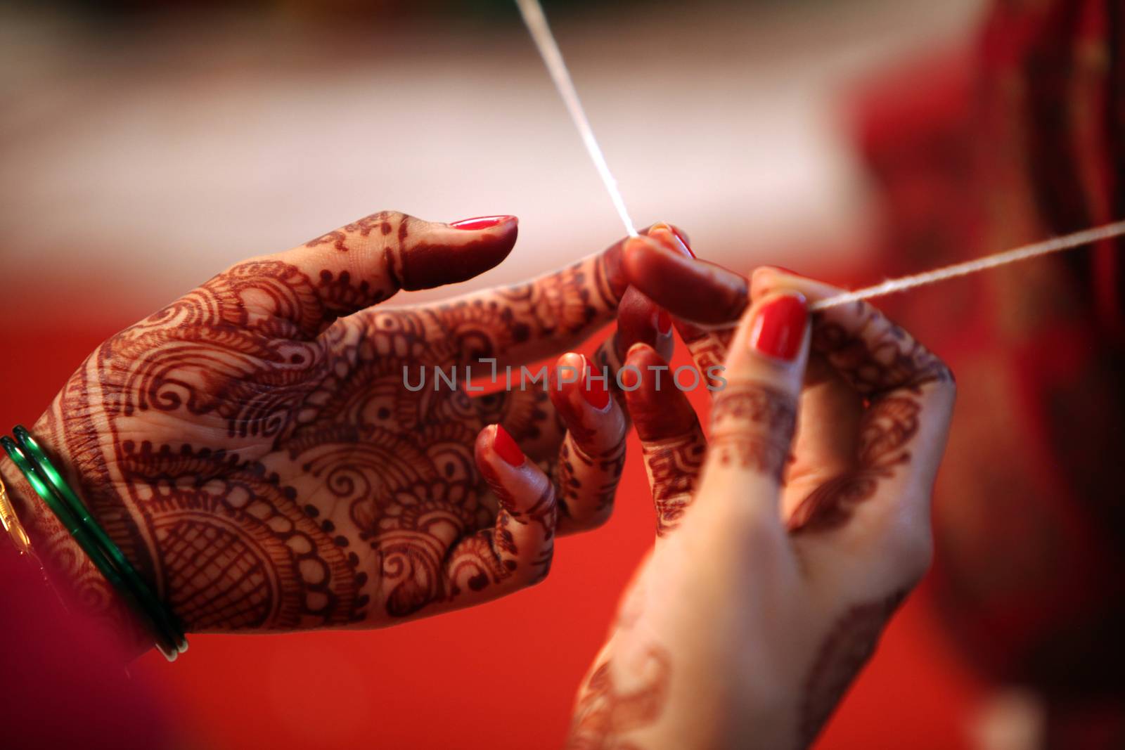 A religious thread held tight in the hands of a relative during a traditional hindu wedding ceremony.