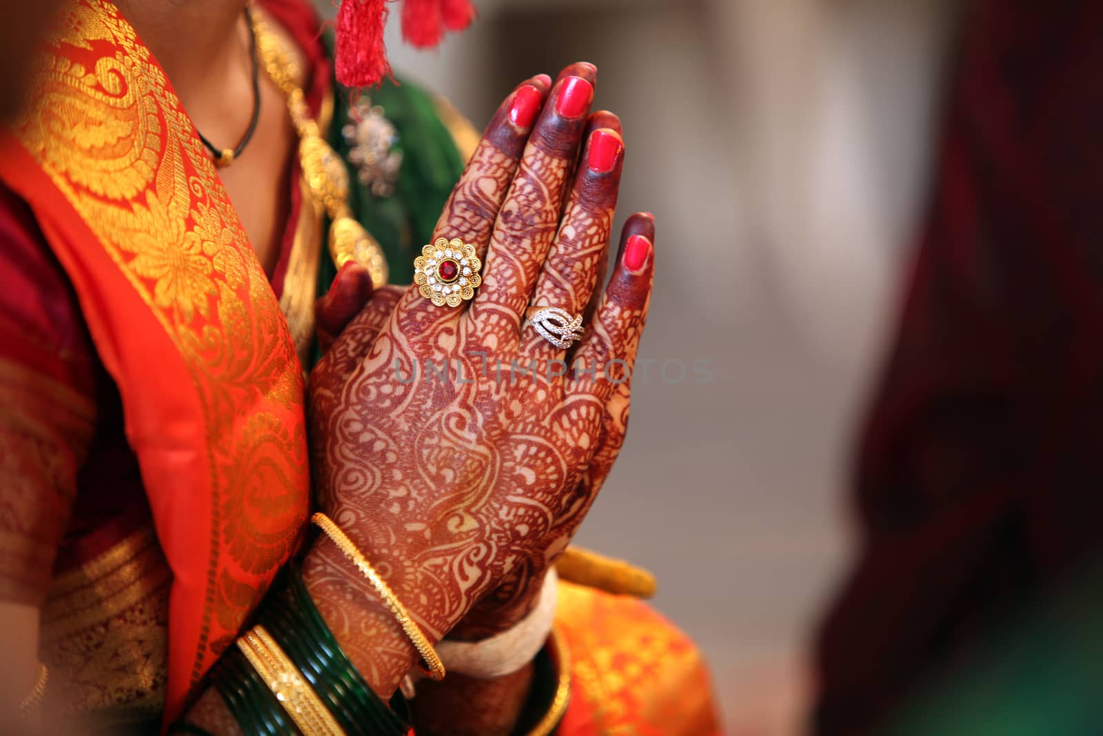 Folder hands of a traditional Indian bride in wedding attire, praying during her wedding.