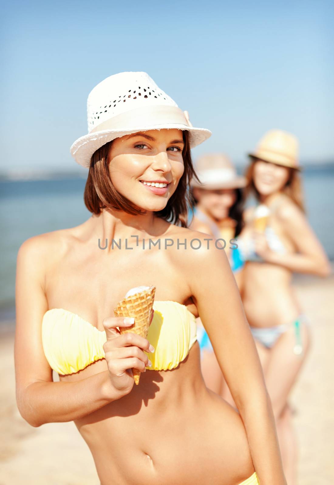 girl in bikini eating ice cream on the beach by dolgachov