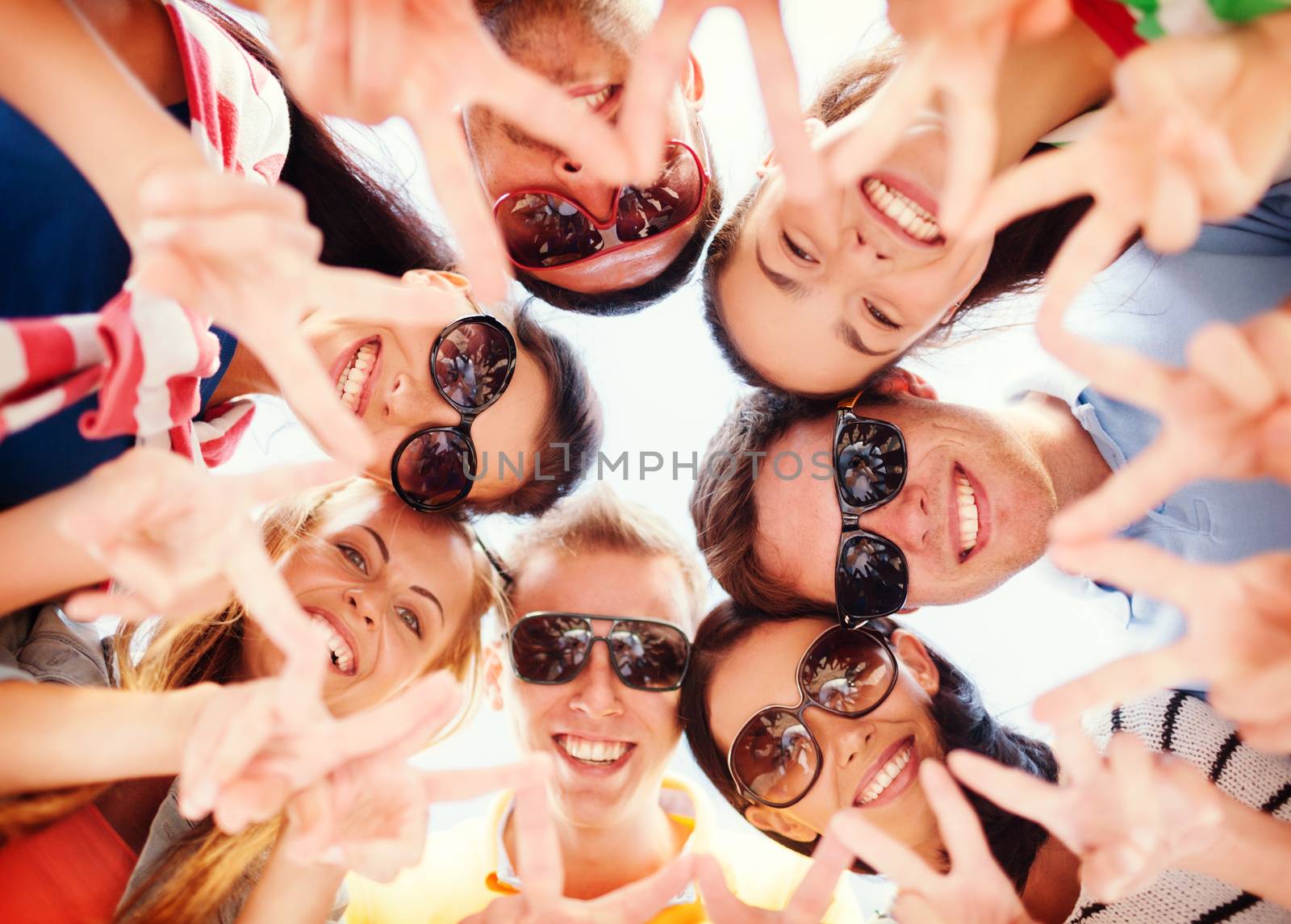 summer, holidays, vacation, happy people concept - group of teenagers looking down and showing finger five gesture