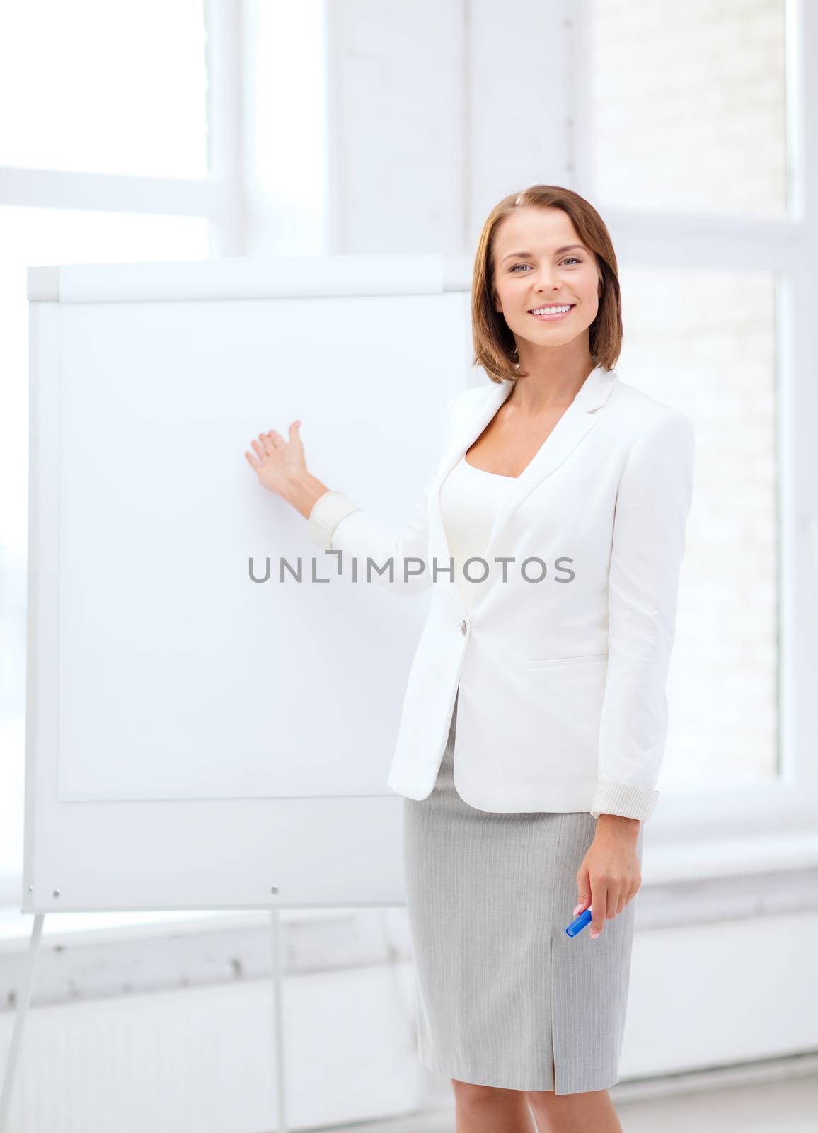 business and education concept - smiling businesswoman showing flipchart