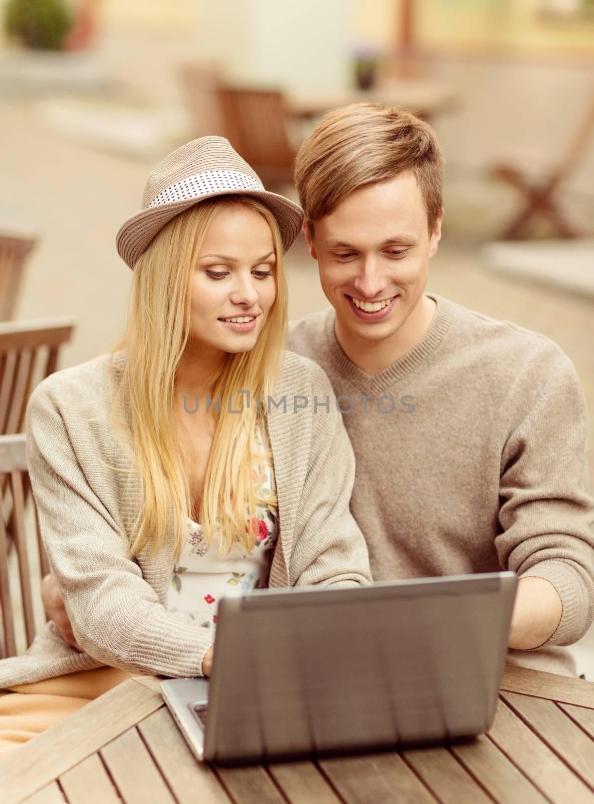 couple with laptop in cafe by dolgachov