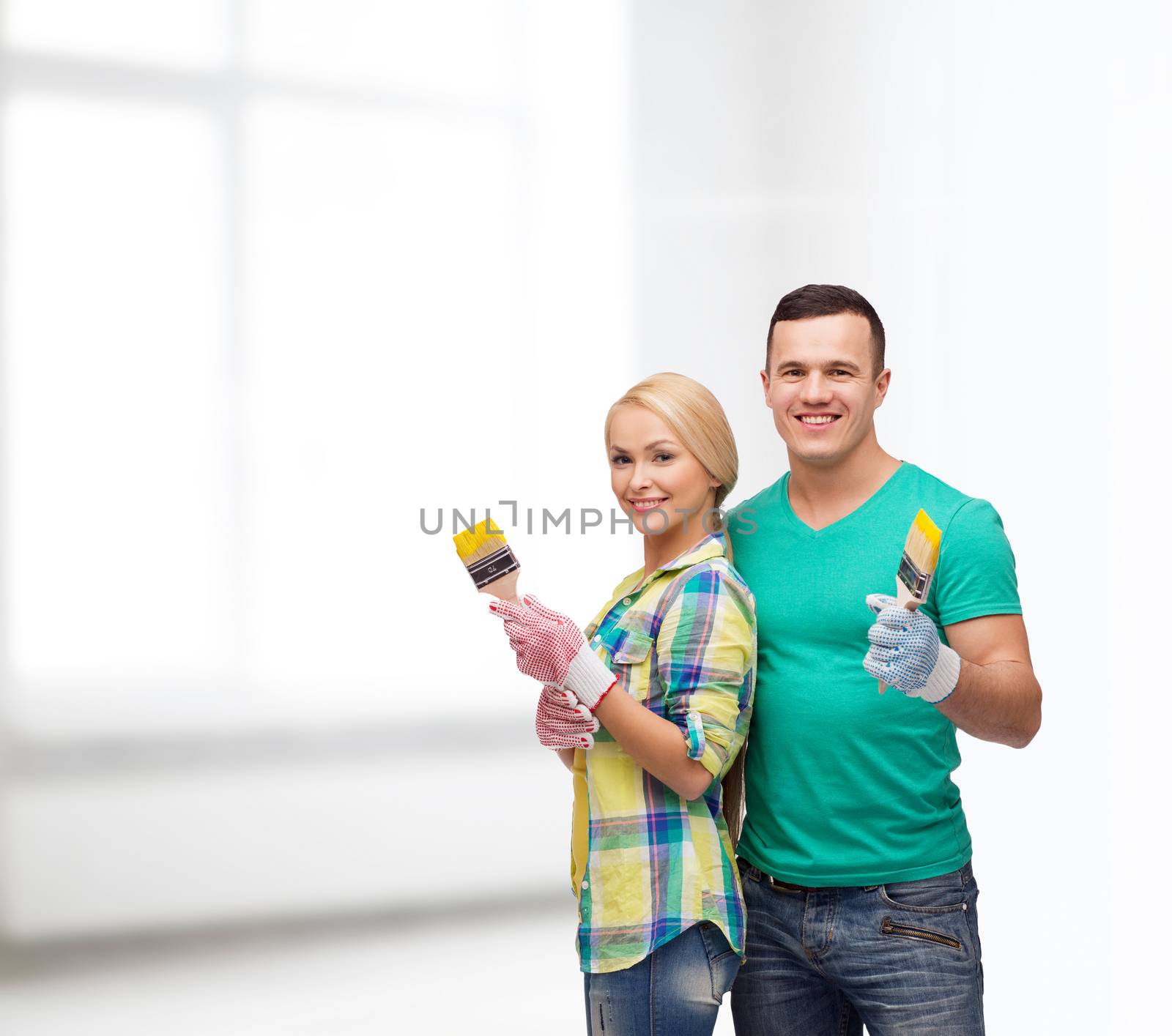 smiling couple with paintbrush by dolgachov
