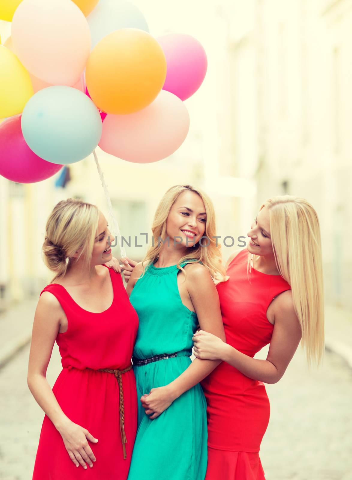 celebration and happy people concept - beautiful girls with colorful balloons in the city