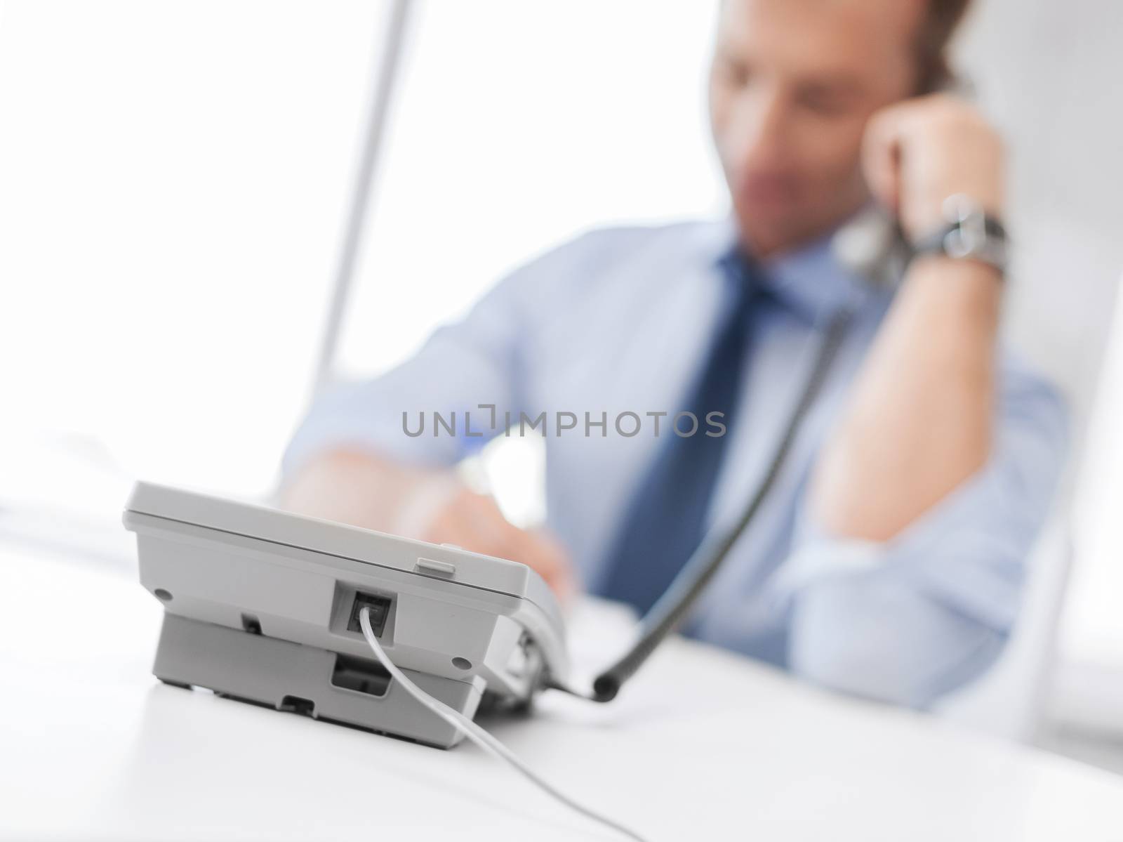 business, office, school and education concept - businessman talking on the phone