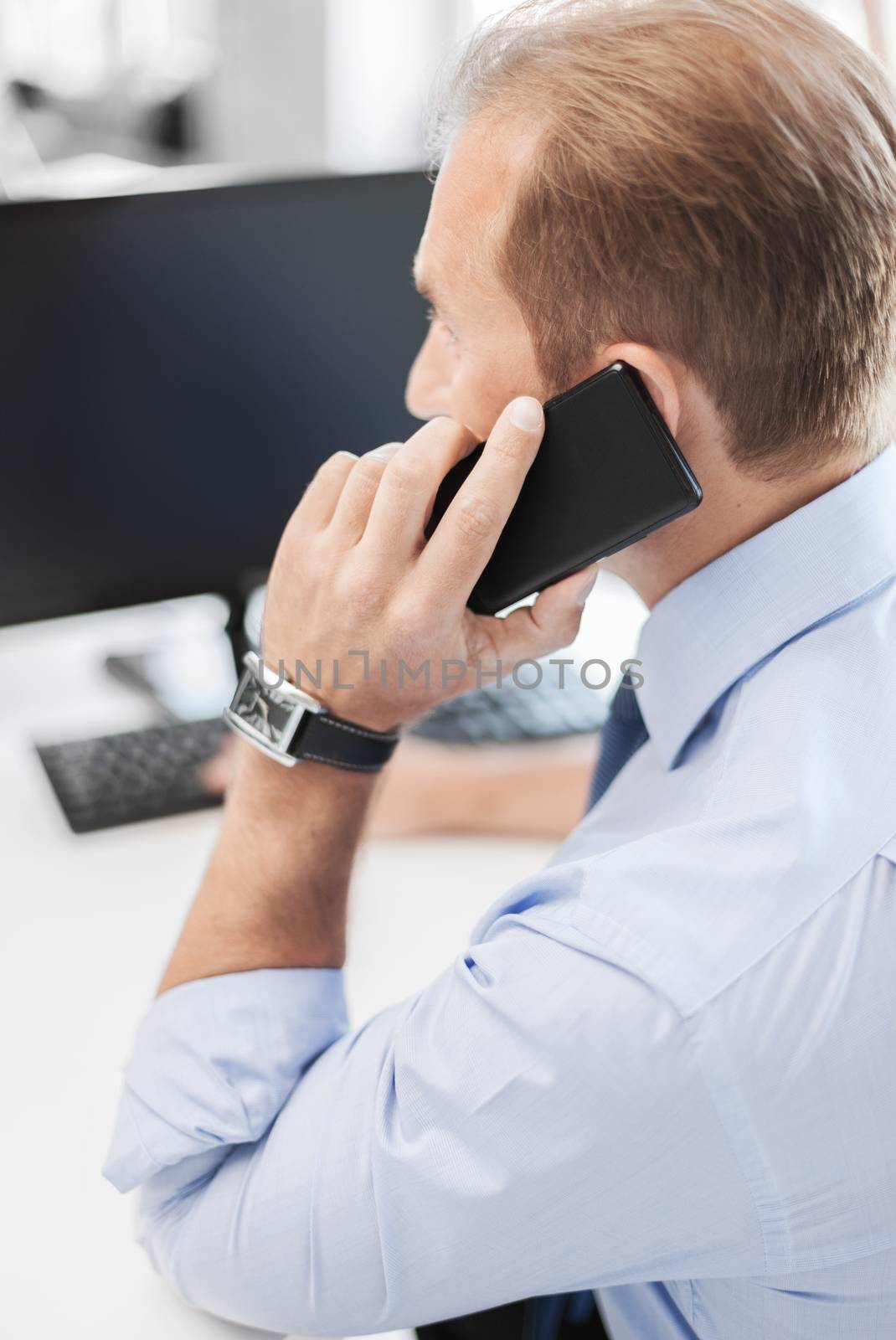 business, technology and office concept - businessman with smartphone in office