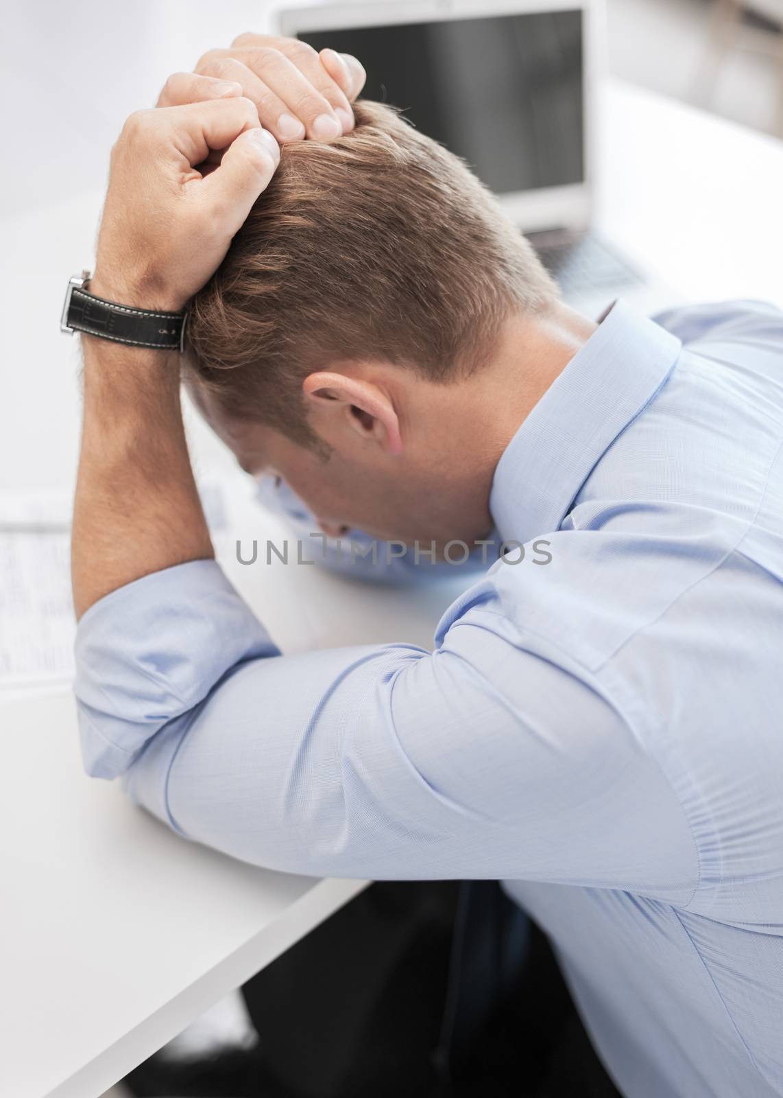 stressed businessman with papers at work by dolgachov