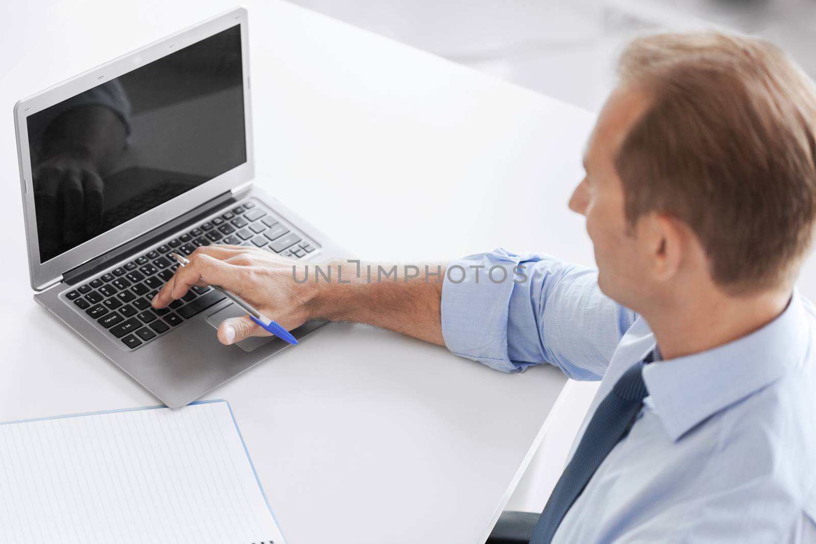 business, technology and office concept - smiling businessman working in office