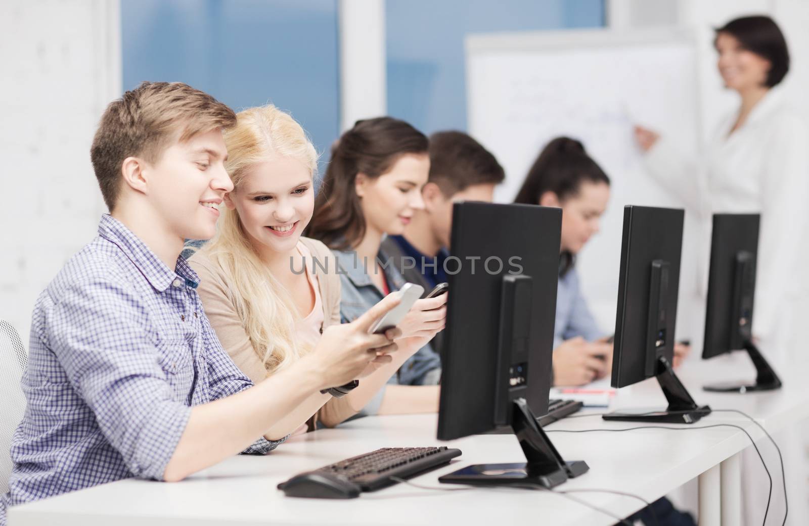 students with computer monitor and smartphones by dolgachov