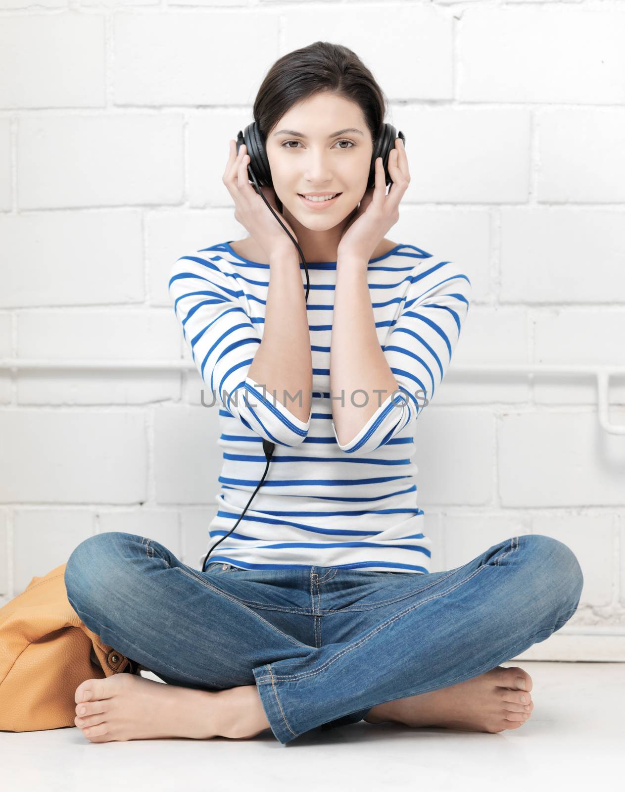 happy teenage girl in big headphones by dolgachov