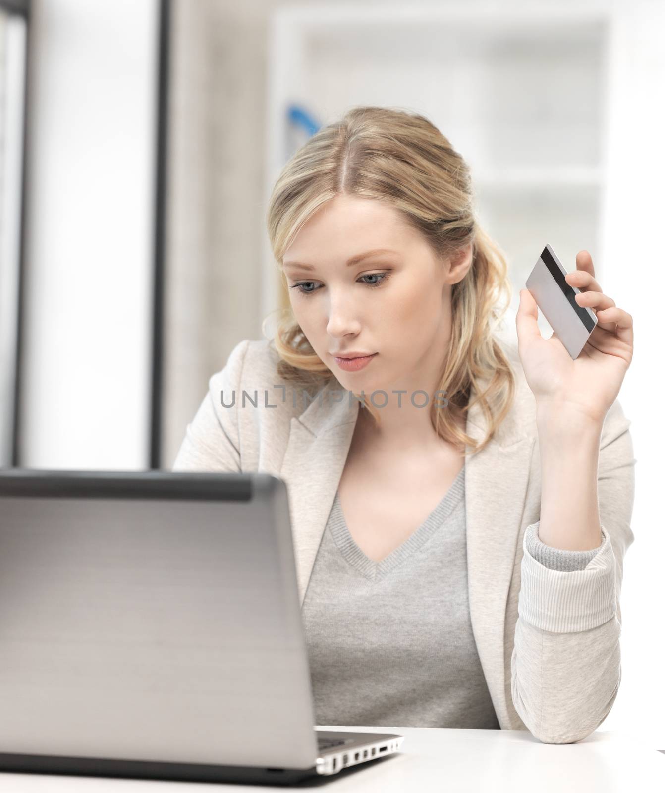 serious woman with laptop computer and credit card by dolgachov