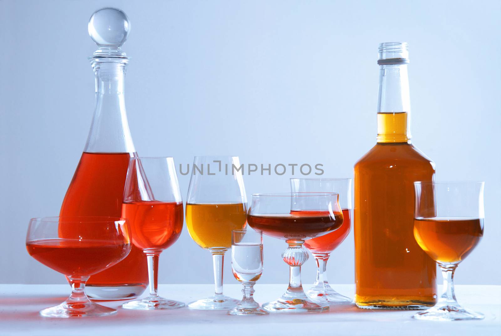 Alcohol conceptual image. Glasses and bottle of wine and whisky on isolated background.