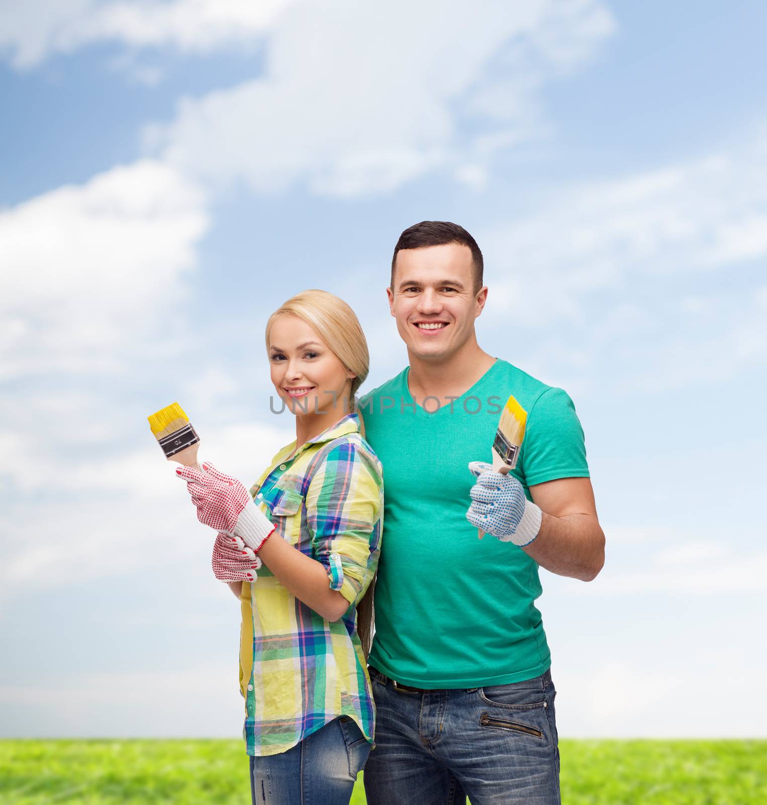 repair, construction and maintenance concept - smiling couple with paintbrush