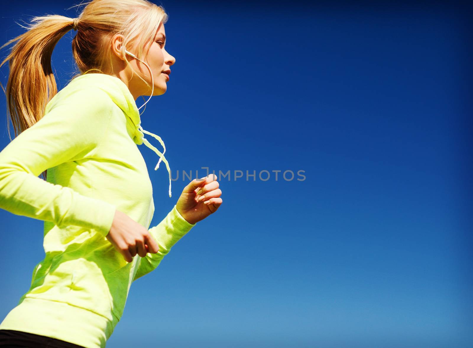 sport and lifestyle concept - woman doing running with earphones outdoors