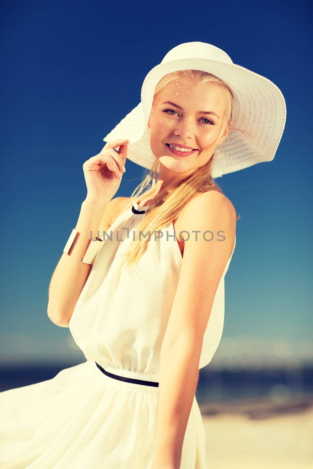 fashion and lifestyle concept - beautiful woman in hat enjoying summer outdoors