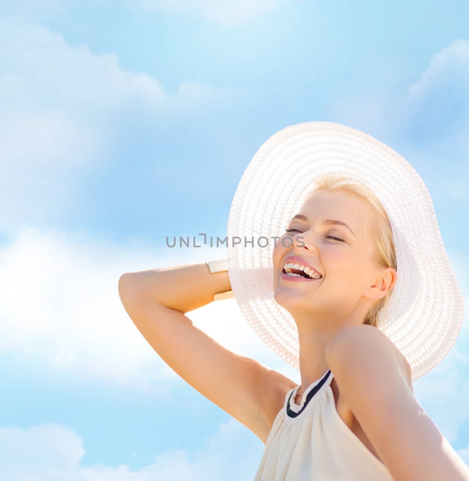 fashion, happiness and lifestyle concept - beautiful woman in hat enjoying summer outdoors