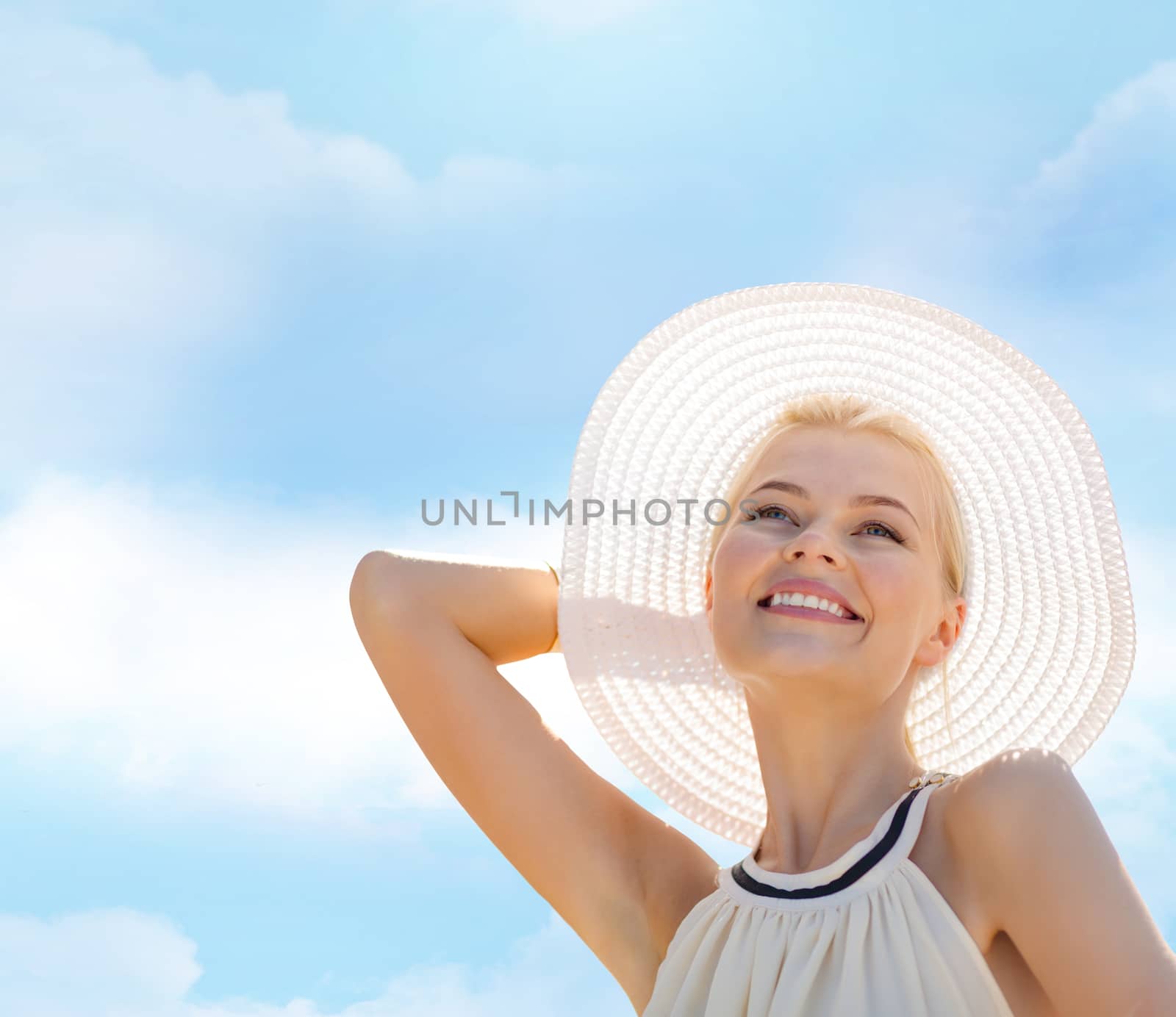 fashion, happiness and lifestyle concept - beautiful woman in hat enjoying summer outdoors