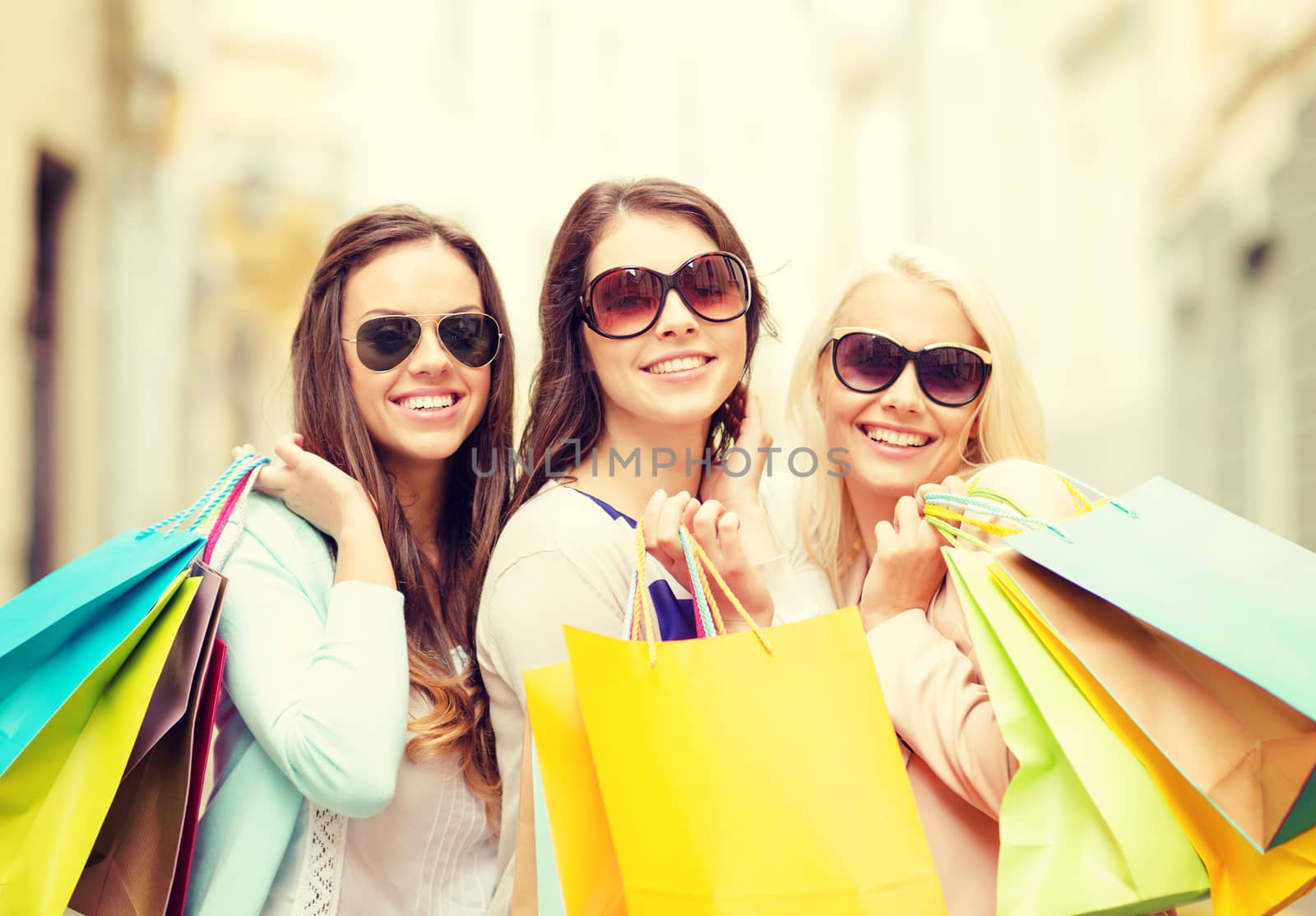 three smiling girls with shopping bags in city by dolgachov