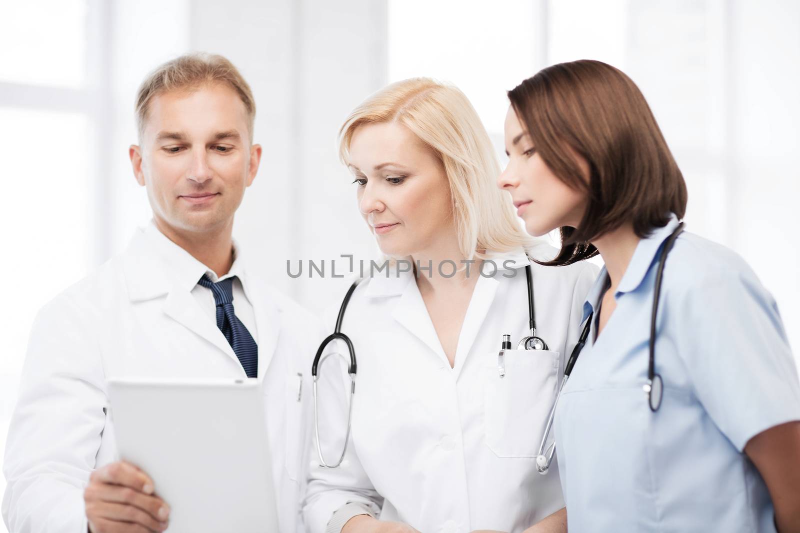 doctors looking at tablet pc by dolgachov