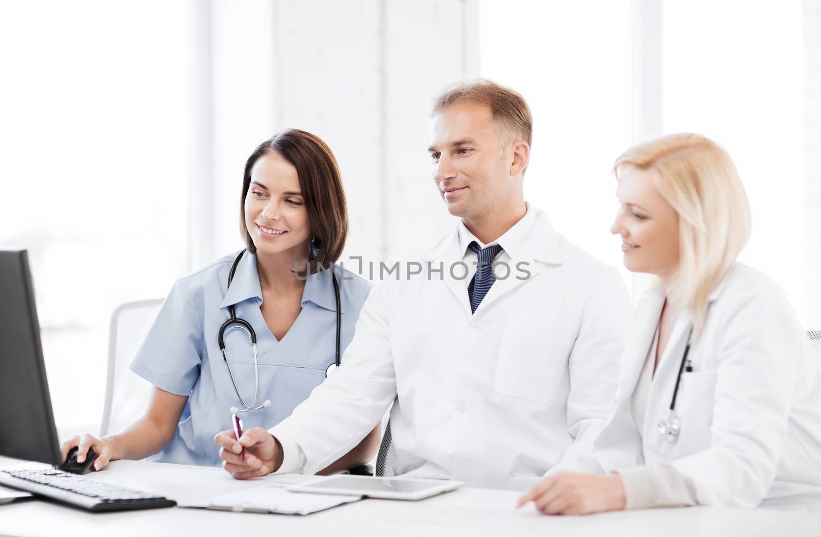 healthcare, medical and technology - group of doctors looking at computer on meeting