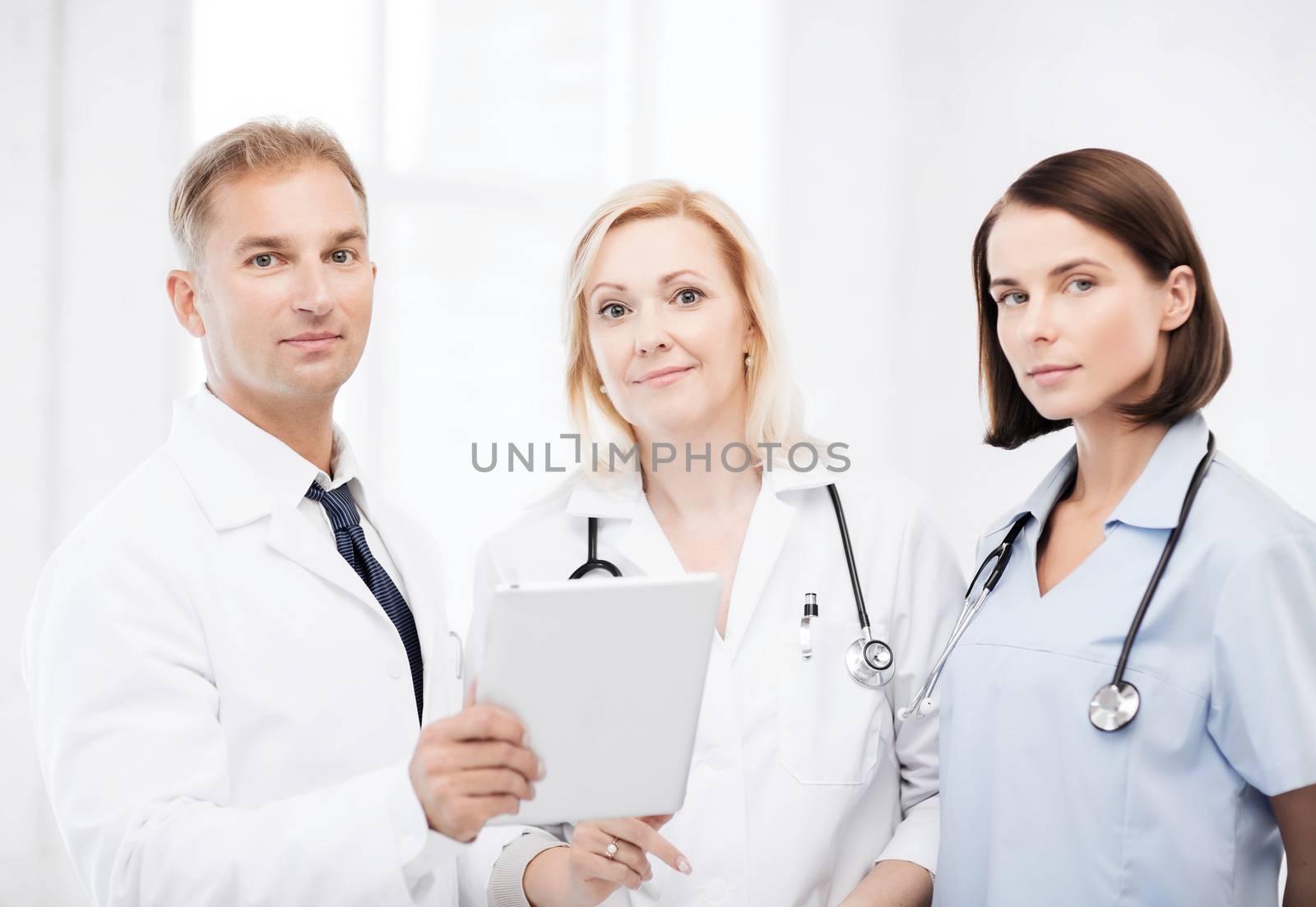 doctors looking at tablet pc by dolgachov