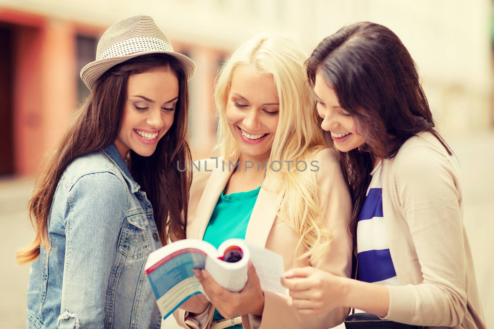 beautiful girls looking into tourist book in city by dolgachov