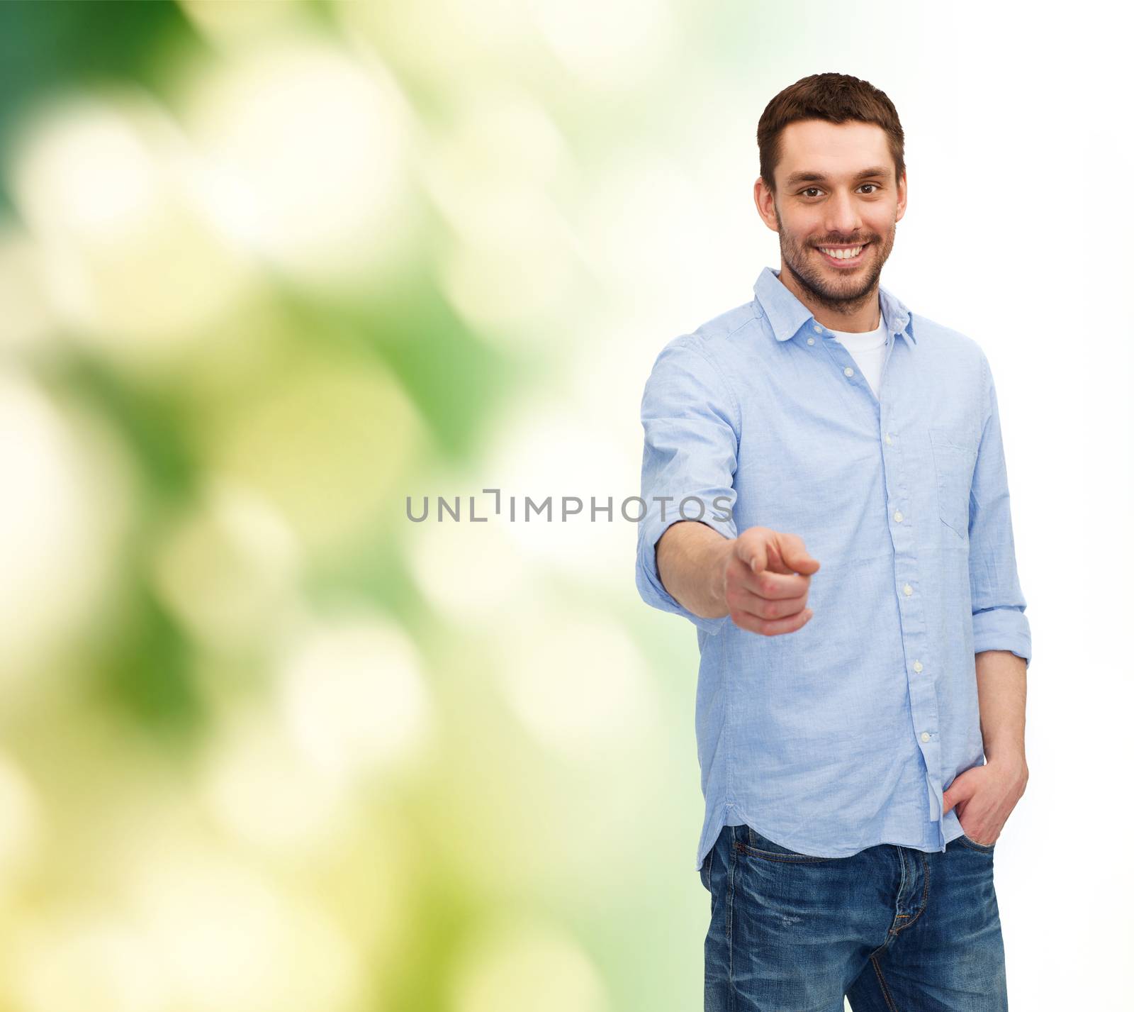 happiness and people concept - smiling man pointing finger at you