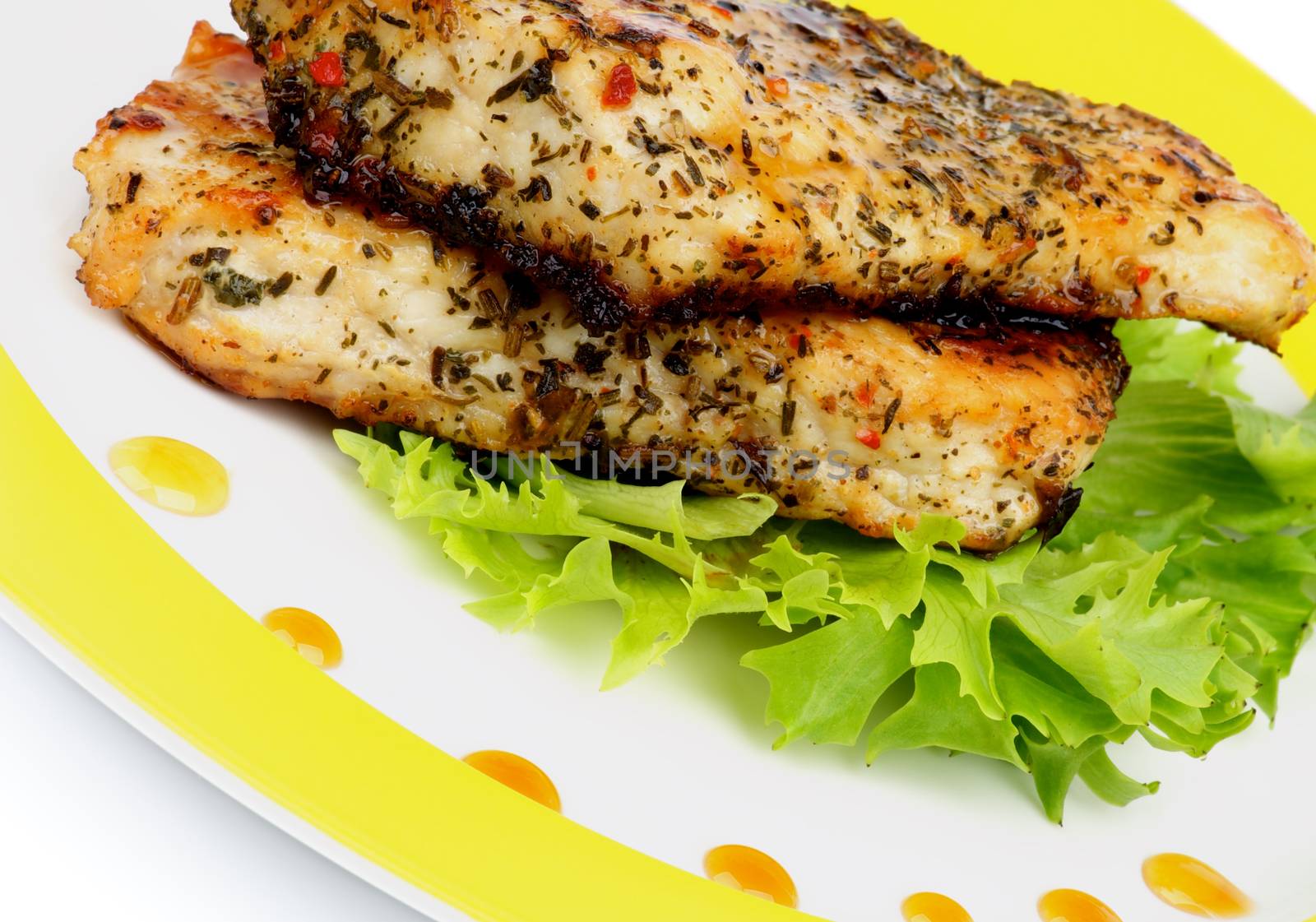 Roasted Chicken Fillets with Herbs, Lettuce and Honey Sauce on Yellow Plate closeup