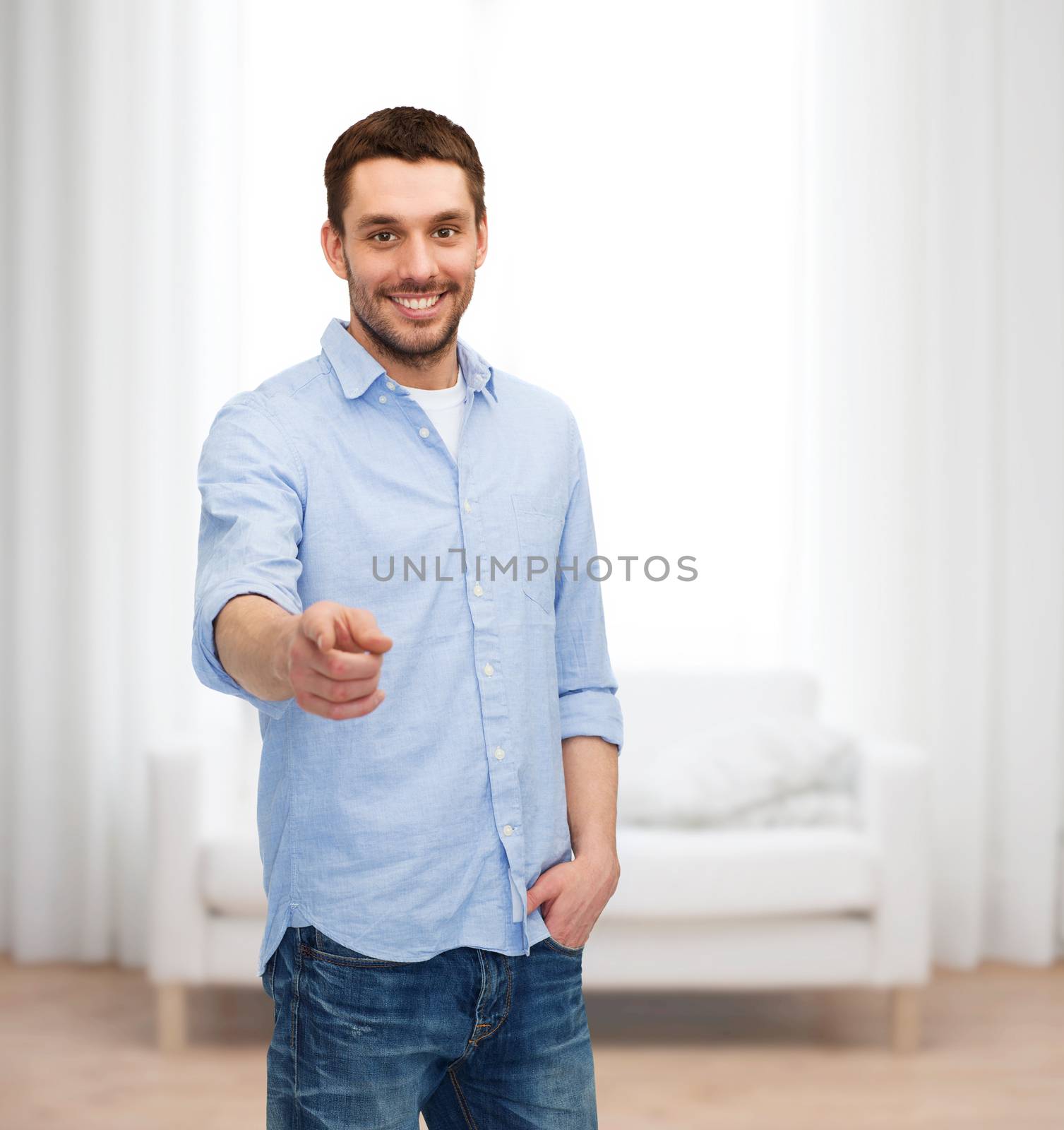 happiness and people concept - smiling man pointing finger at you