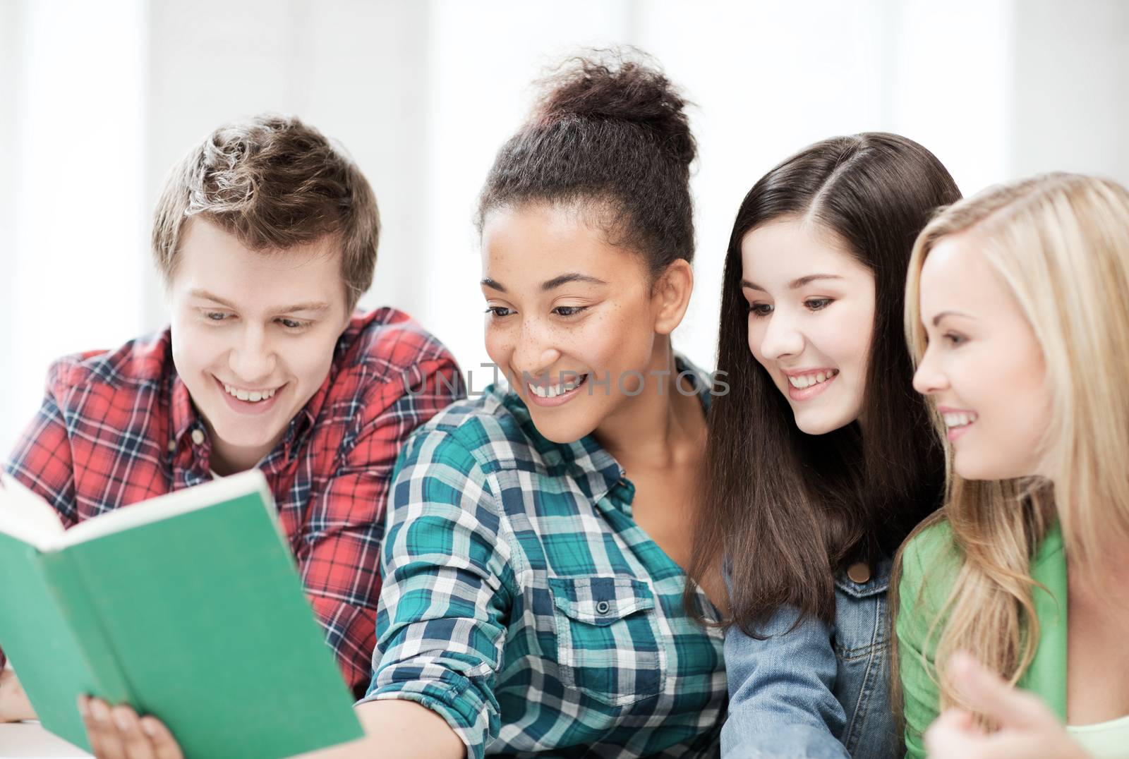 education concept - group of students reading book at school