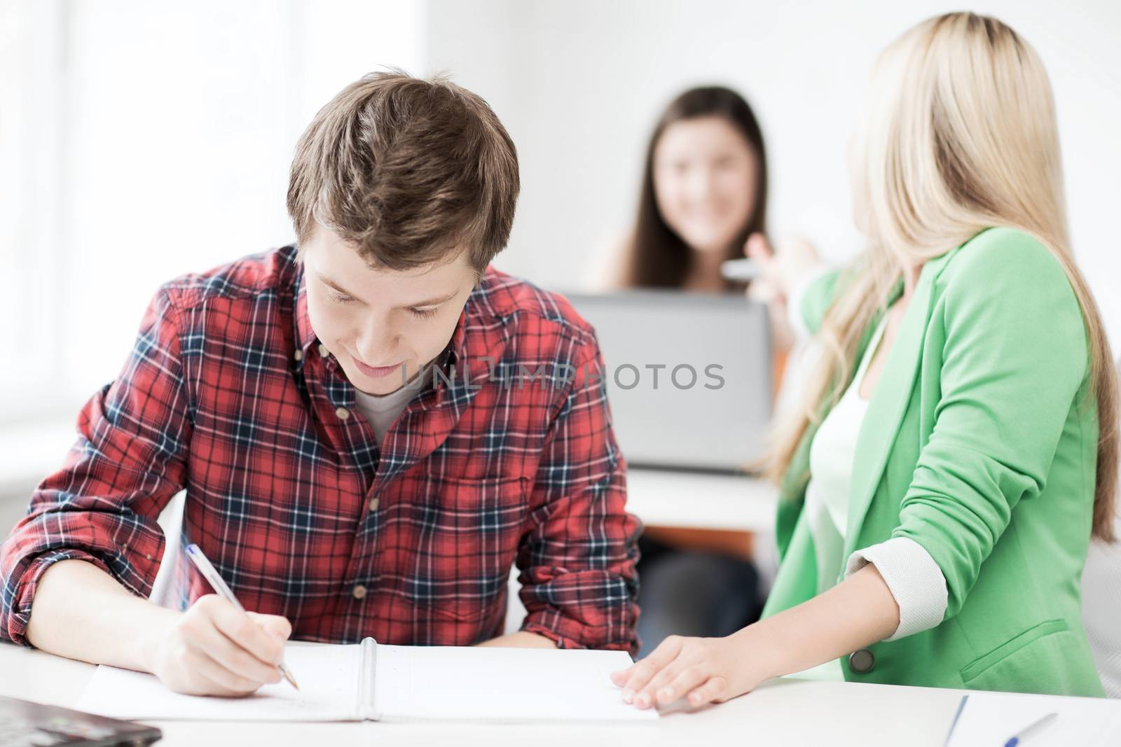 students writing something at school by dolgachov