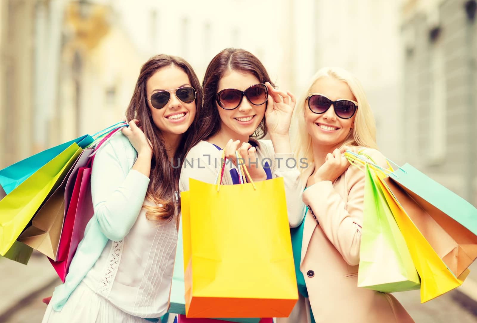 three smiling girls with shopping bags in ctiy by dolgachov