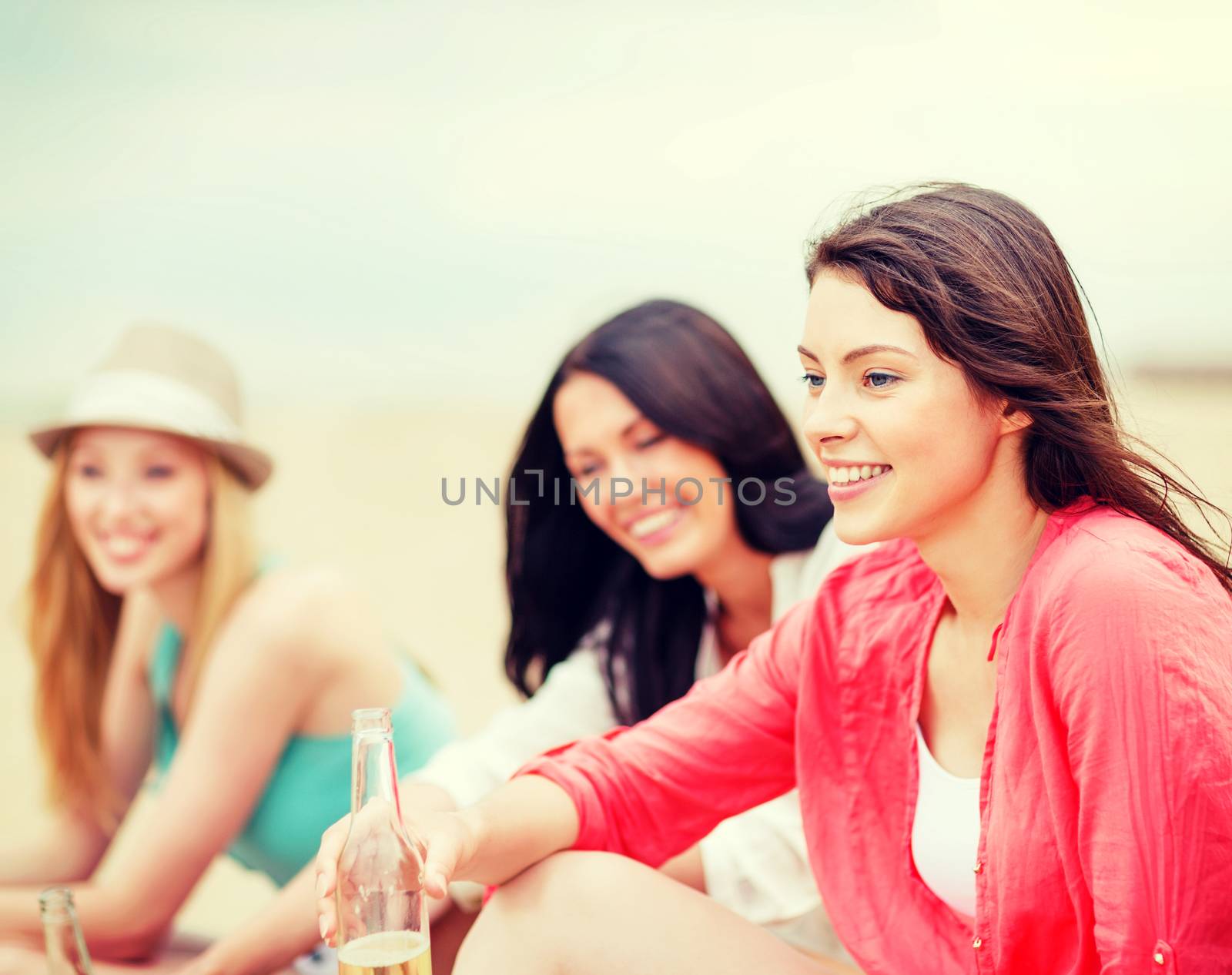 summer holidays and vacation - girls with drinks on the beach