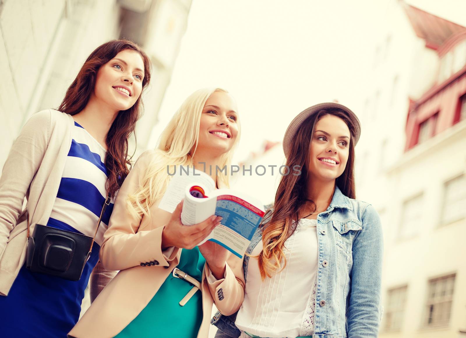 three beautiful girls with tourist book in city by dolgachov