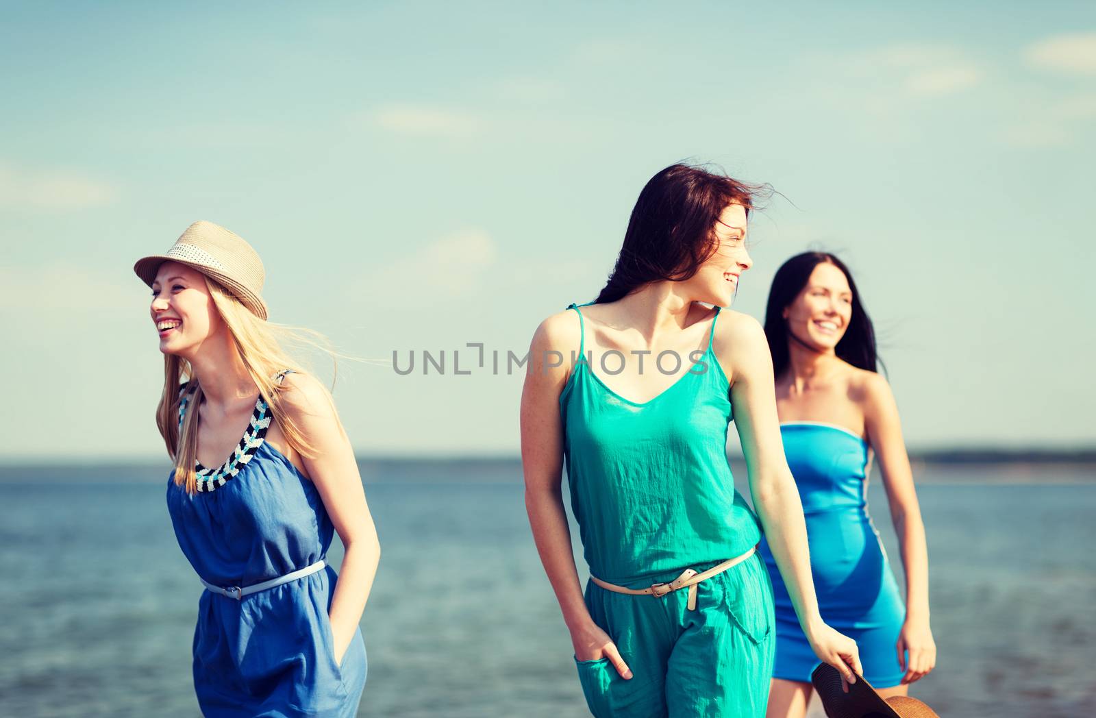 summer holidays and vacation - girls walking on the beach