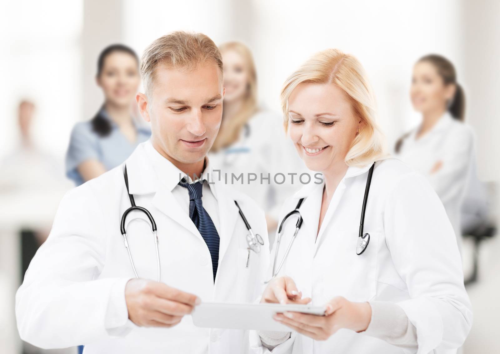 healthcare and technology concept - two doctors looking at tablet pc