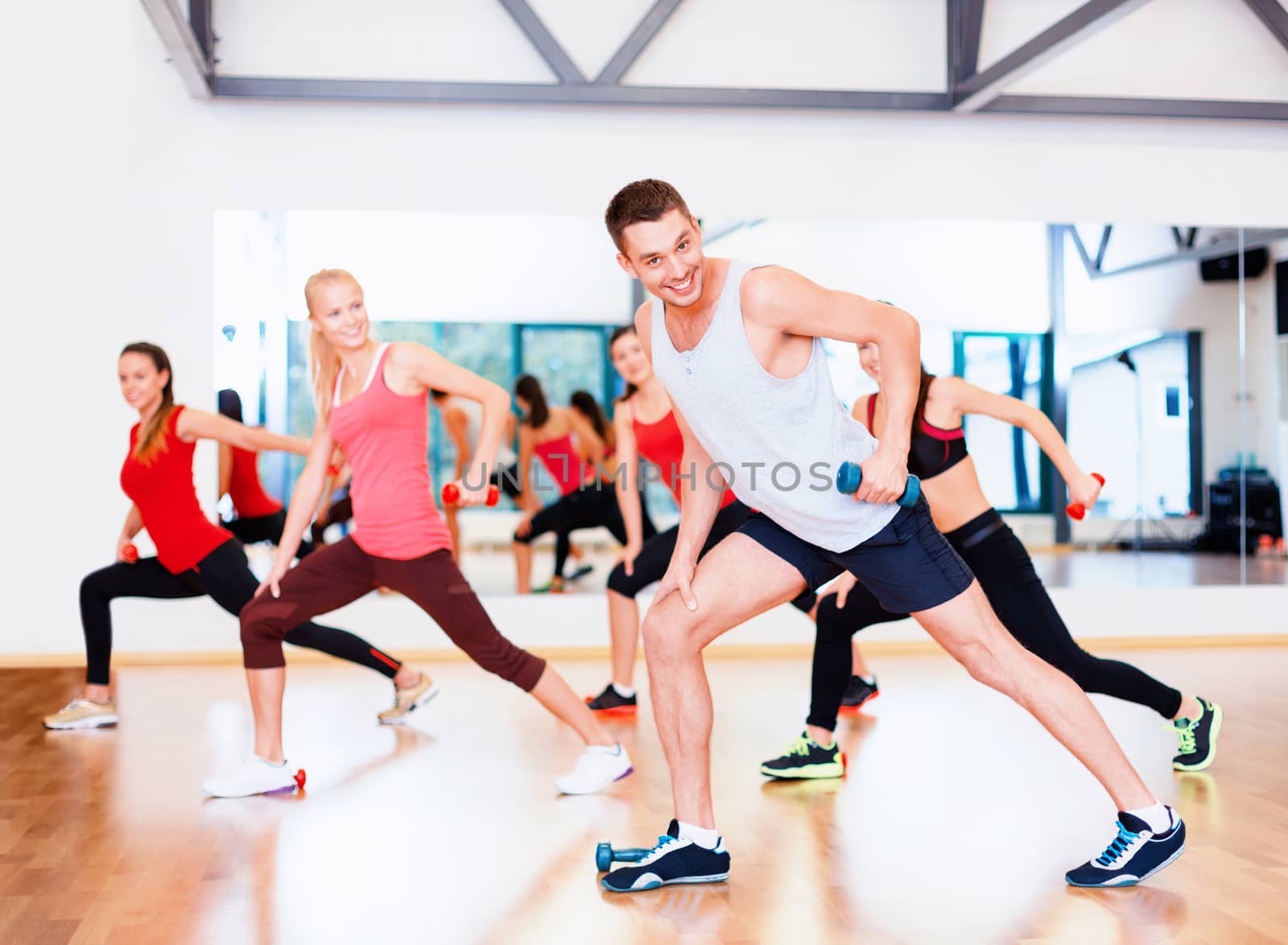 group of smiling people working out with dumbbells by dolgachov