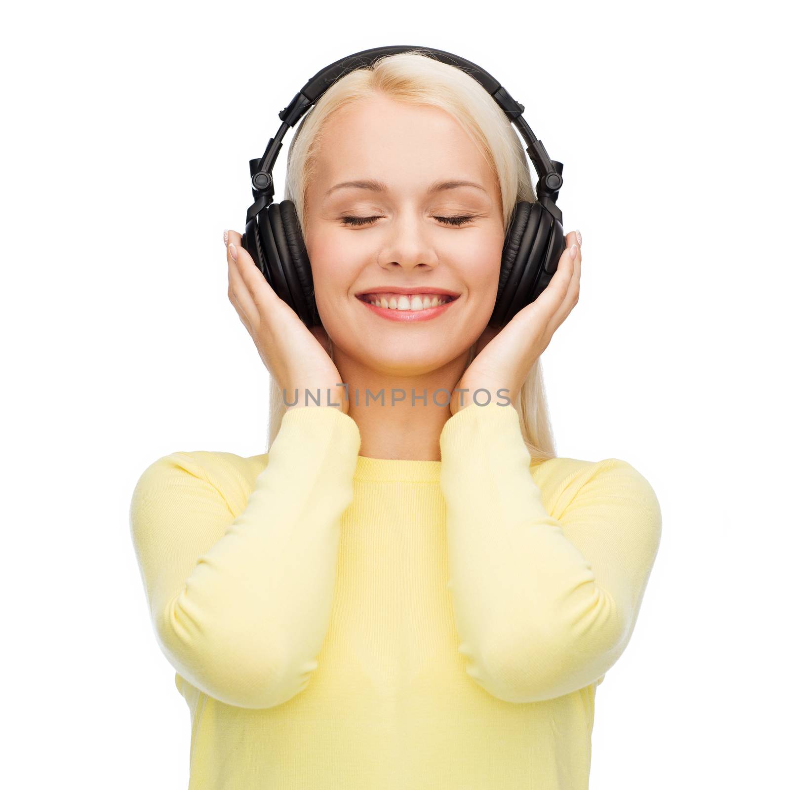 music and technology concept - smiling young woman with closed eyes listening to music with headphones