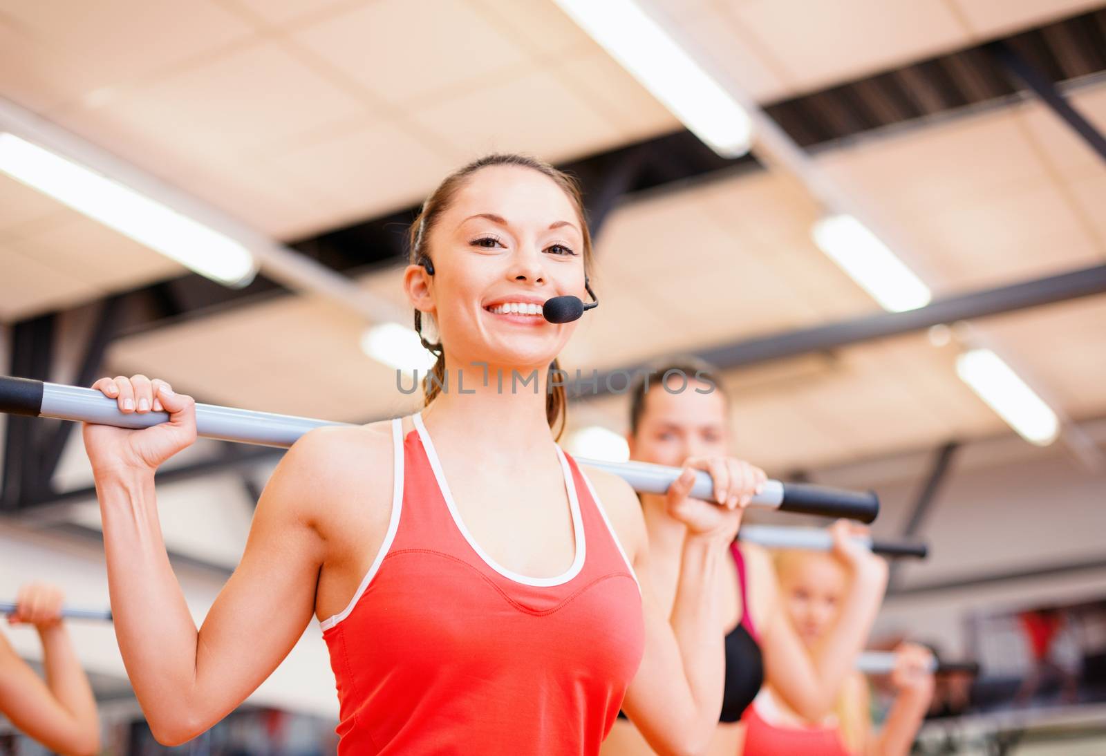 group of smiling people working out with barbells by dolgachov