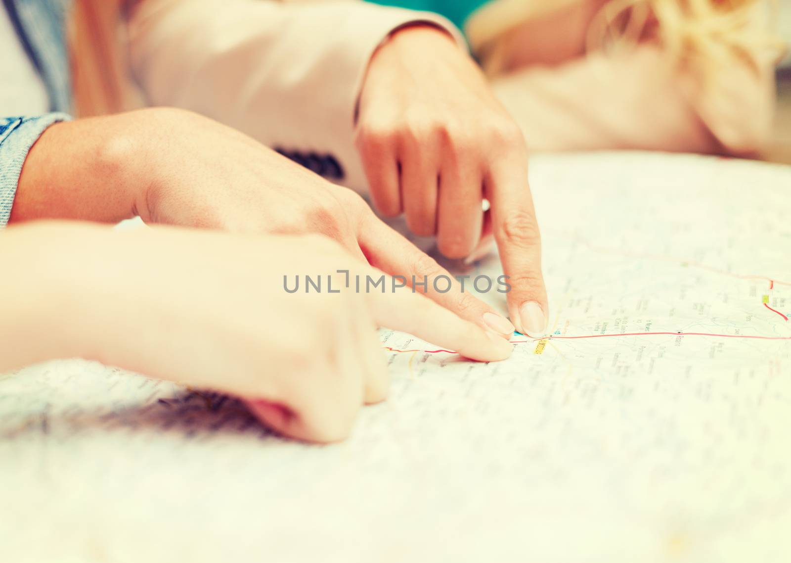 holidays and tourism concept - women with tourist map in the city