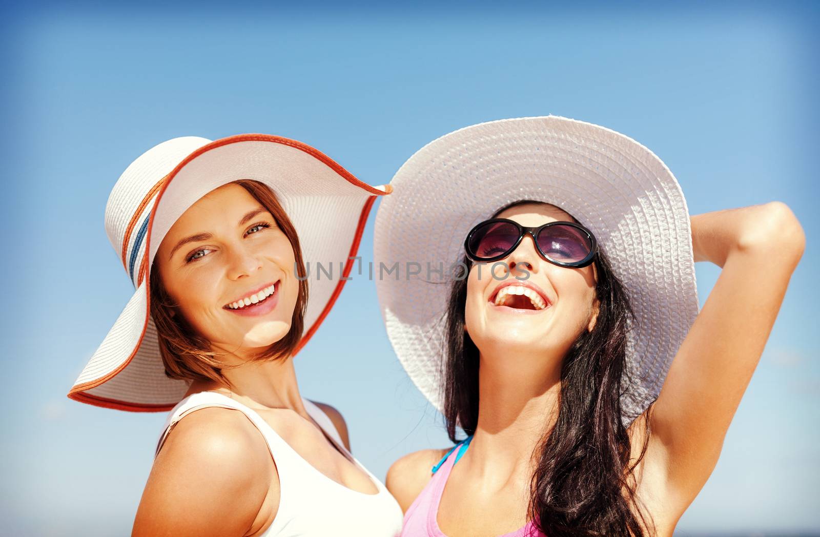 girls in hats on the beach by dolgachov