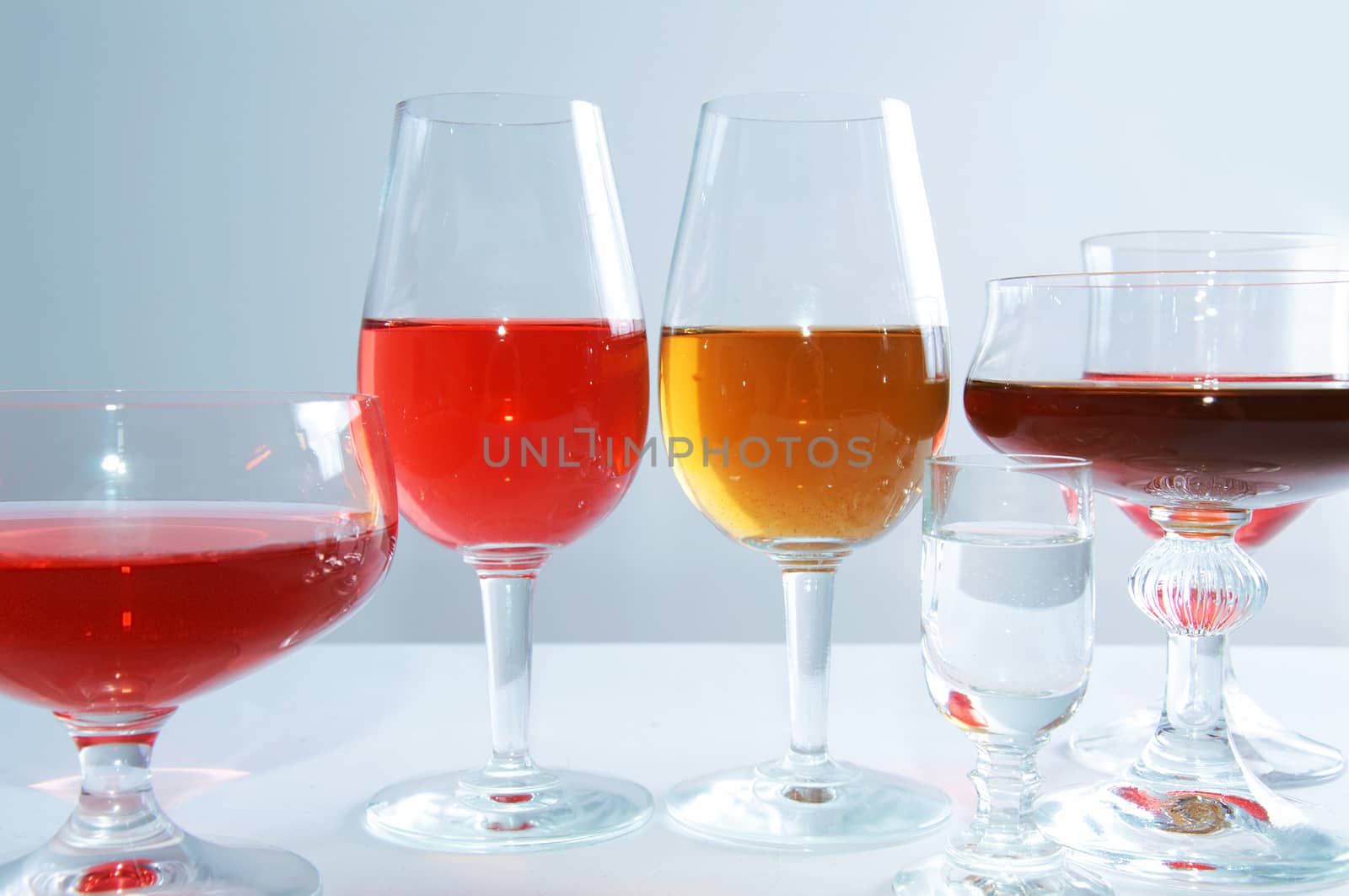 Alcohol conceptual image. Glasses full of wine and whisky on isolated background.