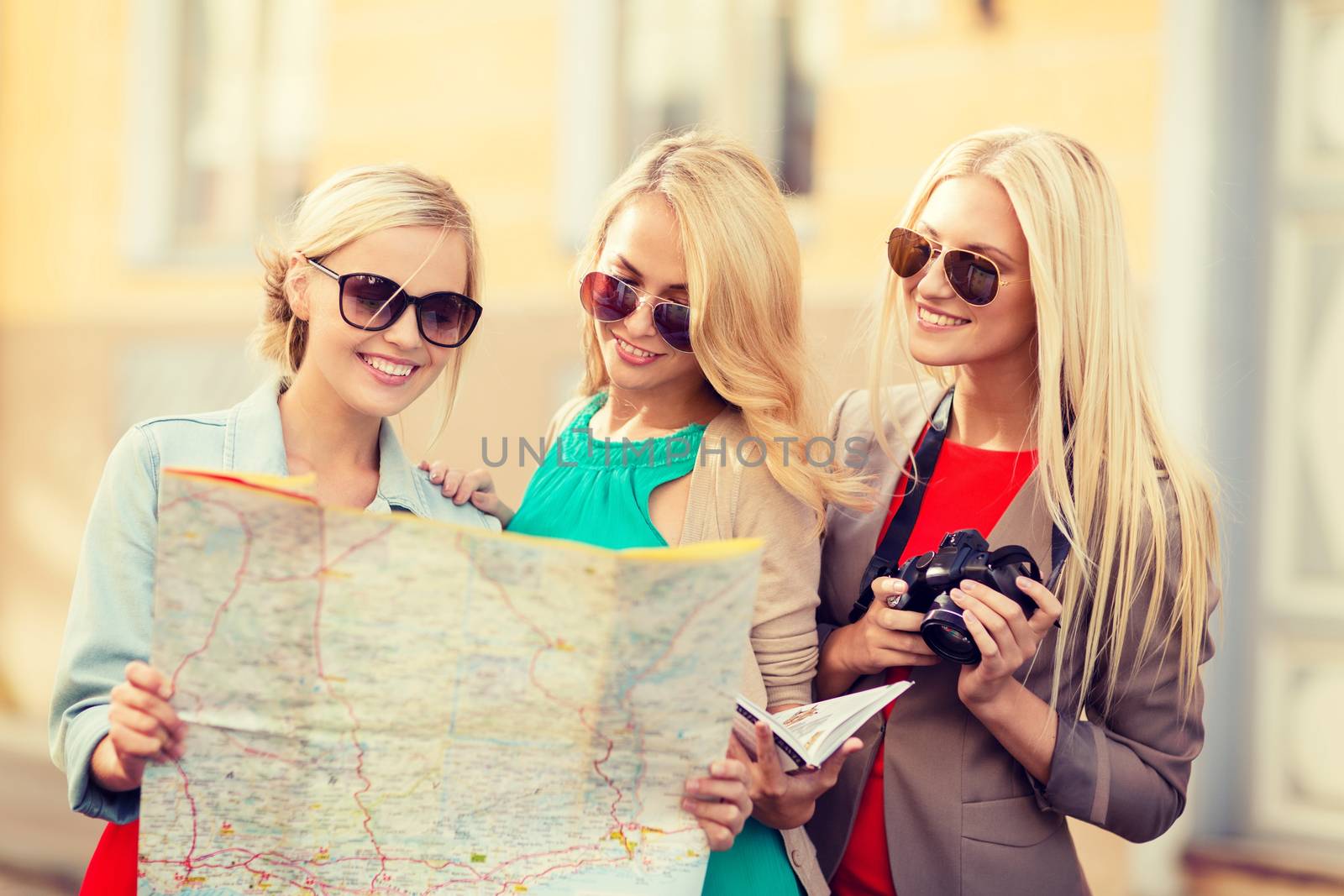 holidays and tourism concept - beautiful blonde women with tourist map in the city