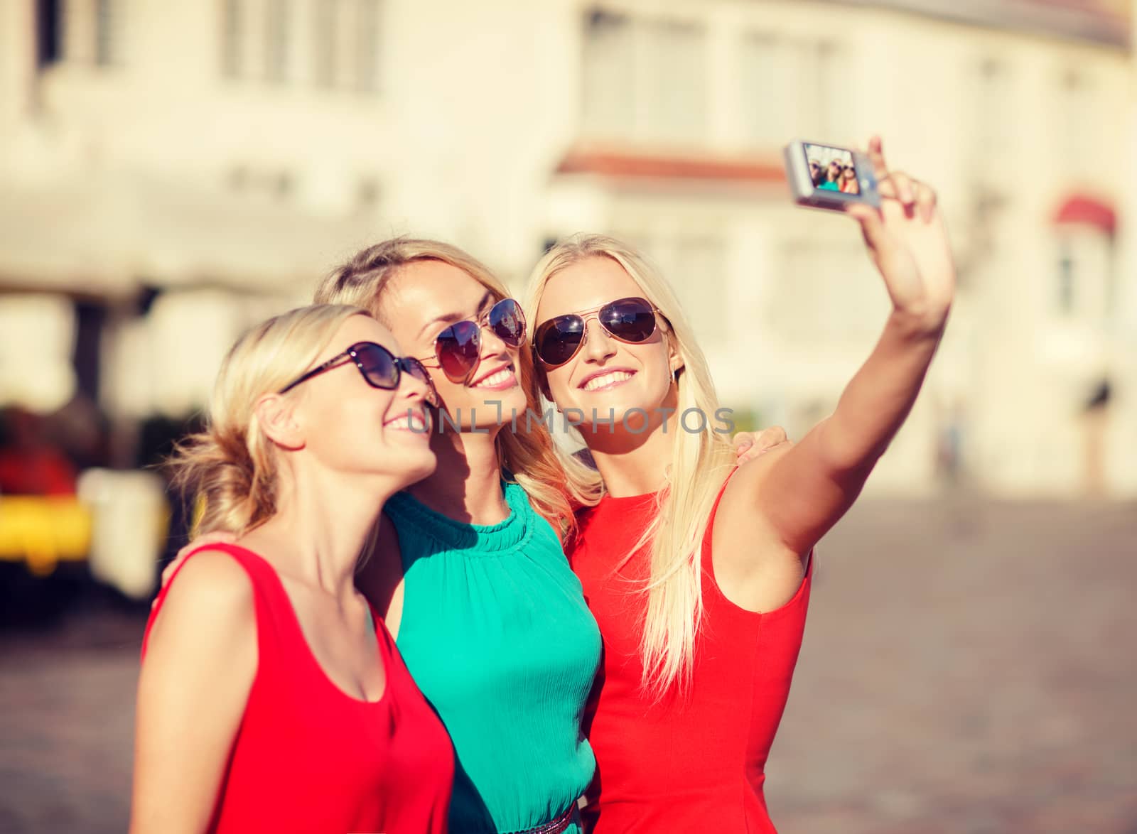 three beautiful girls taking picture in the city by dolgachov