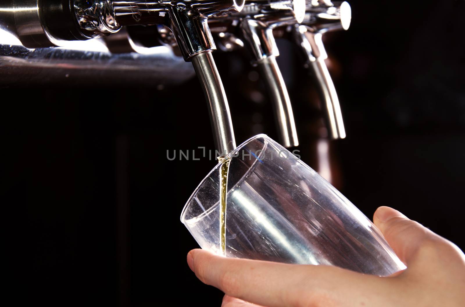 Alcohol conceptual image. Bartender giving the beer from dispenser.