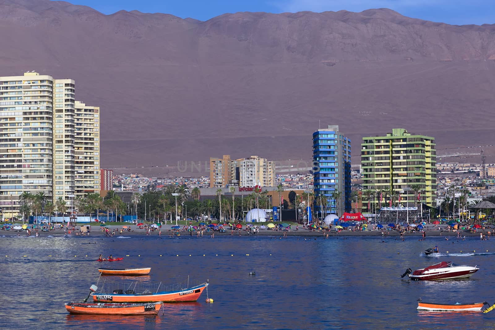 IQUIQUE, CHILE - JANUARY 23, 2015: View from the peninsula at the end of Cavancha beach over the fishing boats anchoring in the bay, Cavancha beach and Arturo Prat Chacon Avenue on January 23, 2015 in Iquique, Chile. Iquique is a popular beach town and free port city in Northern Chile. 