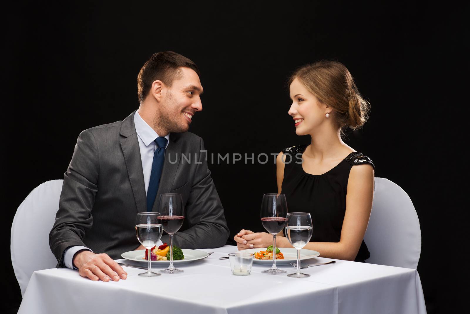 restaurant, couple and holiday concept - smiling couple eating main course with red wine at restaurant